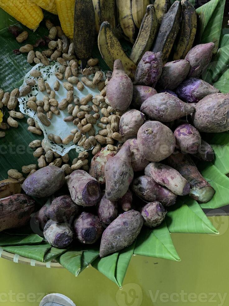 Traditional healthy snacks menu for parties in Indonesia, there are sweet corn, stewed peanuts, potatoes, bananas and breadfruit fresh from steamer. photo