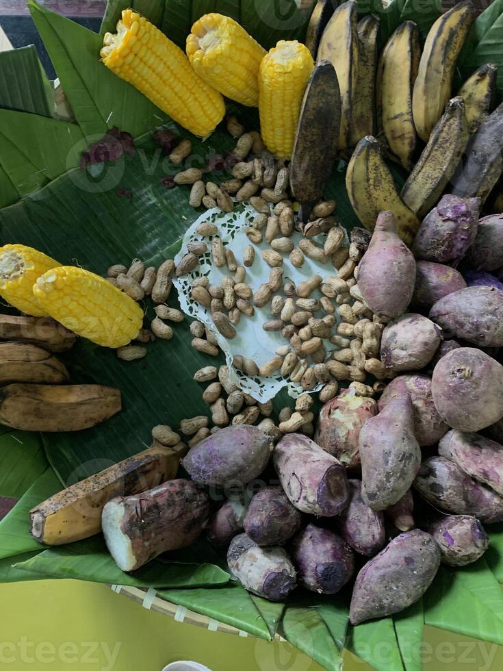 Traditional healthy snacks menu for parties in Indonesia, there are sweet corn, stewed peanuts, potatoes, bananas and breadfruit fresh from steamer. photo