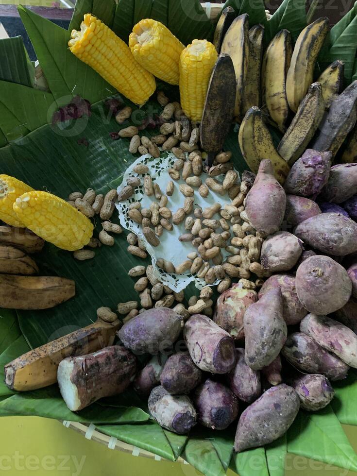 Traditional healthy snacks menu for parties in Indonesia, there are sweet corn, stewed peanuts, potatoes, bananas and breadfruit fresh from steamer. photo
