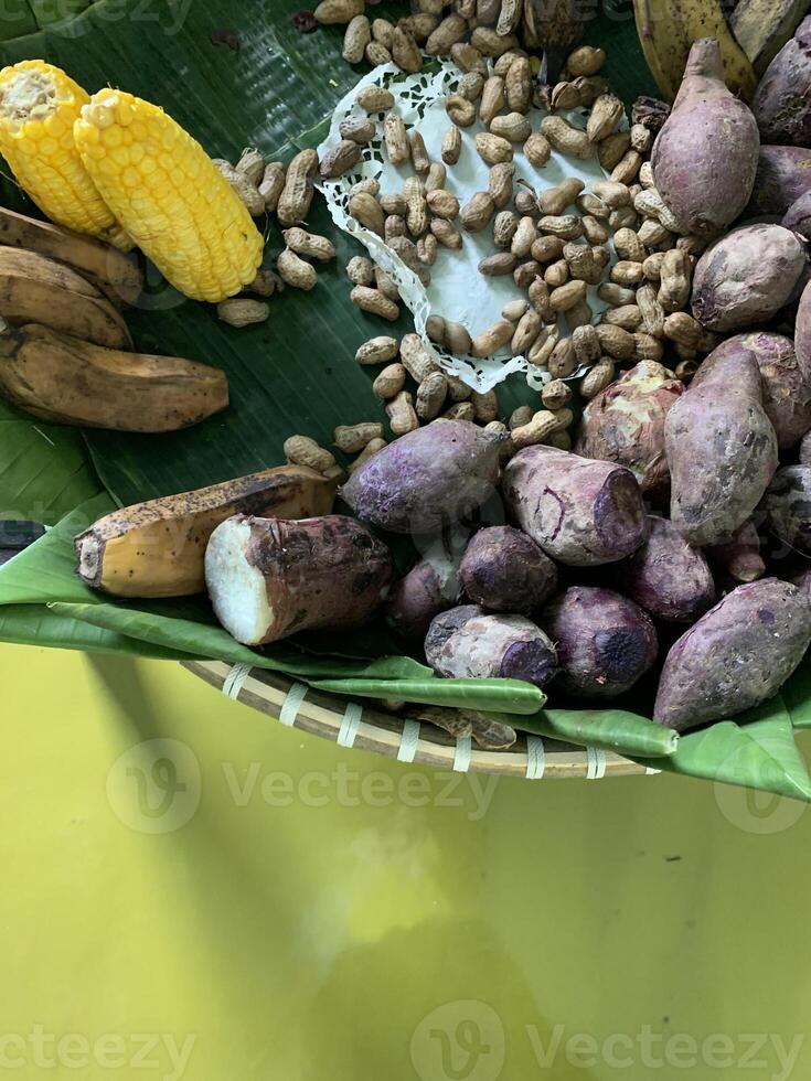 Traditional healthy snacks menu for parties in Indonesia, there are sweet corn, stewed peanuts, potatoes, bananas and breadfruit fresh from steamer. photo