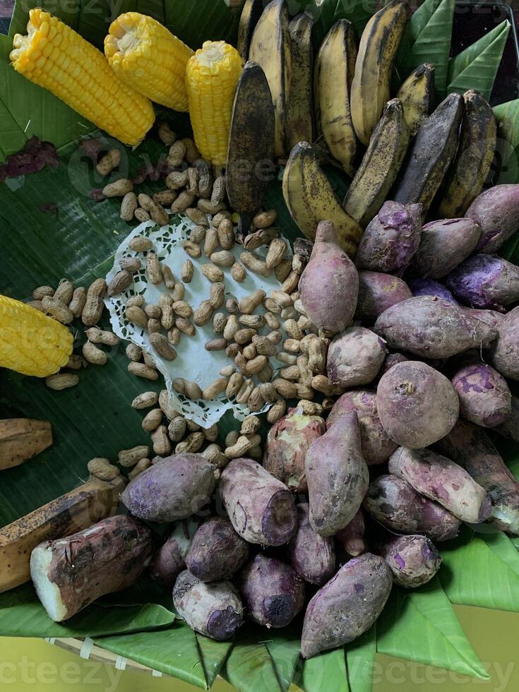 Traditional healthy snacks menu for parties in Indonesia, there are sweet corn, stewed peanuts, potatoes, bananas and breadfruit fresh from steamer. photo