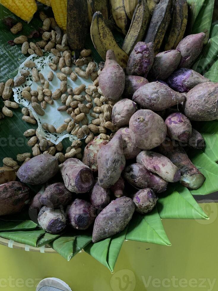 Traditional healthy snacks menu for parties in Indonesia, there are sweet corn, stewed peanuts, potatoes, bananas and breadfruit fresh from steamer. photo