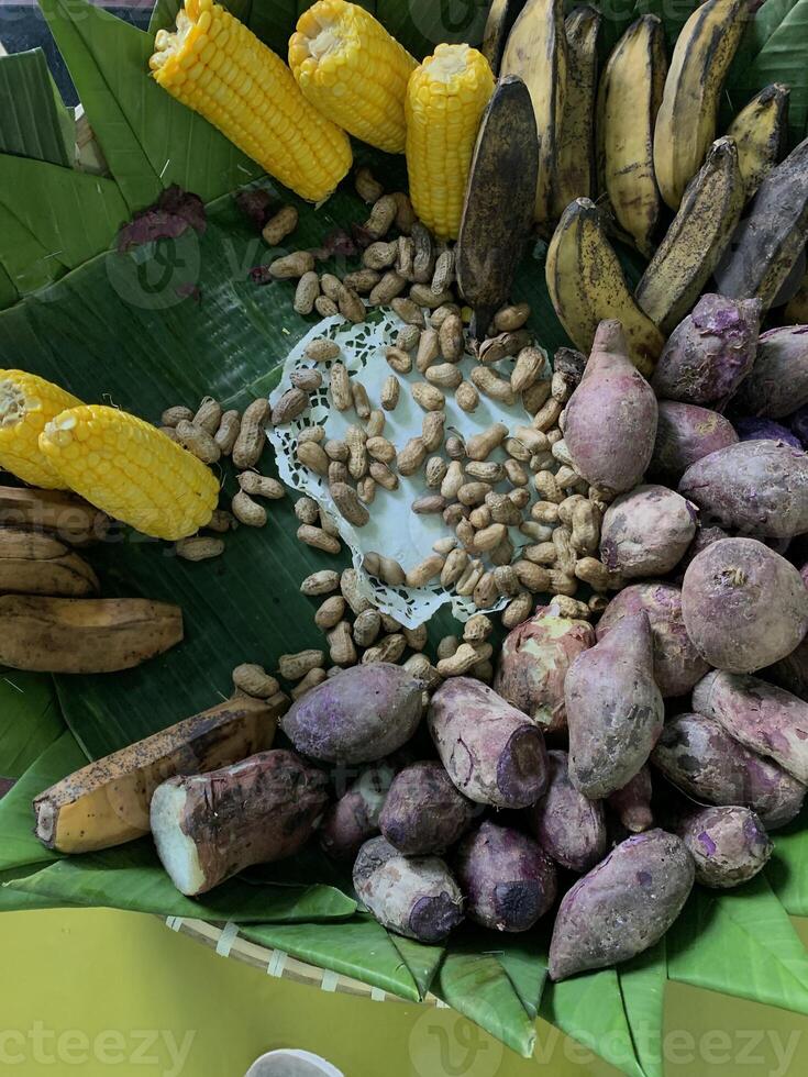 Traditional healthy snacks menu for parties in Indonesia, there are sweet corn, stewed peanuts, potatoes, bananas and breadfruit fresh from steamer. photo