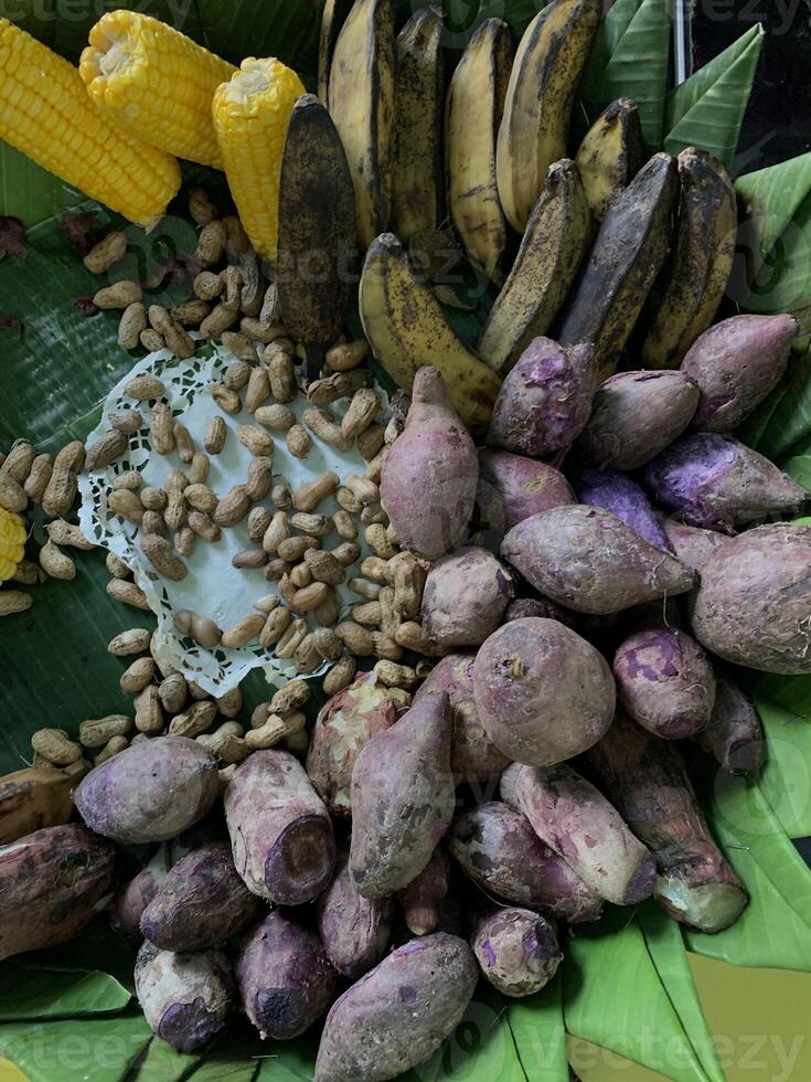 Traditional healthy snacks menu for parties in Indonesia, there are sweet corn, stewed peanuts, potatoes, bananas and breadfruit fresh from steamer. photo