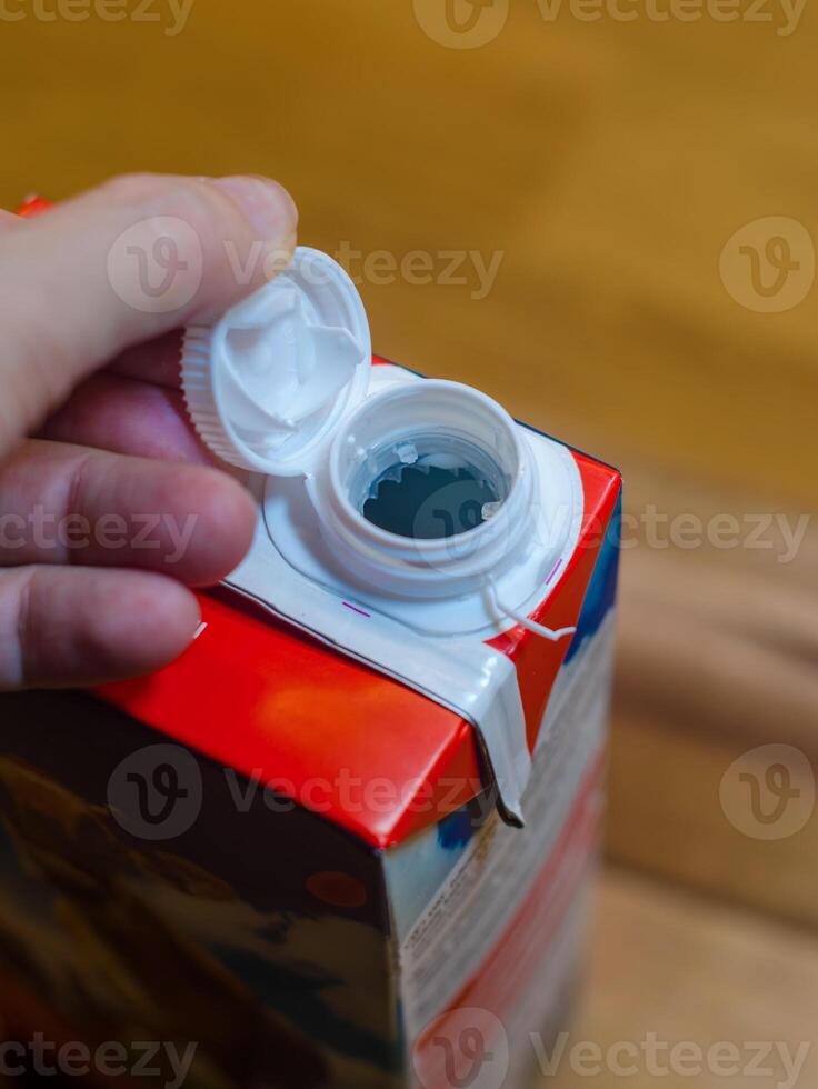 new screw cap a milk Carton with Close-Up View of Hand and Cap Design. High quality photo