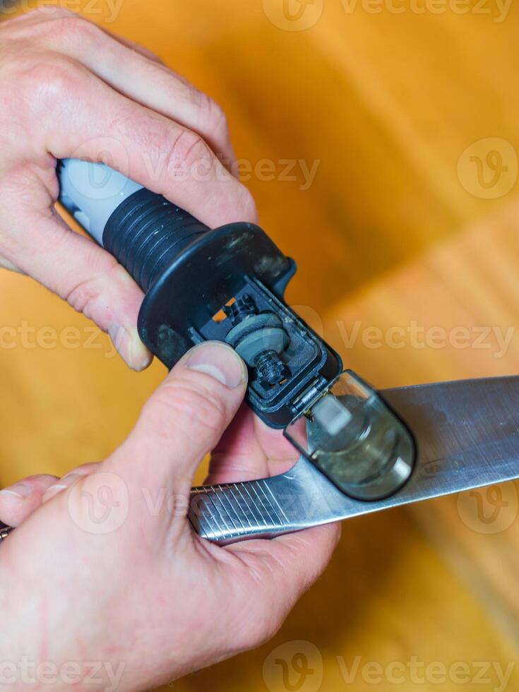 Man sharpening a knife with a handheld sharpener. High quality photo