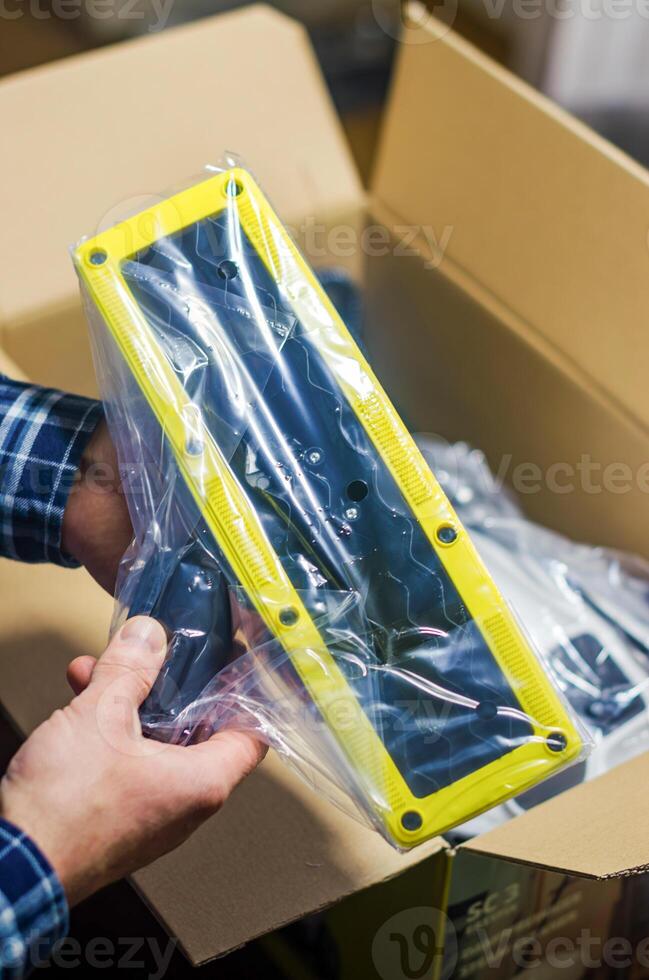 Close-up of a person holding a yellow steam mop attachment from the box. High quality photo