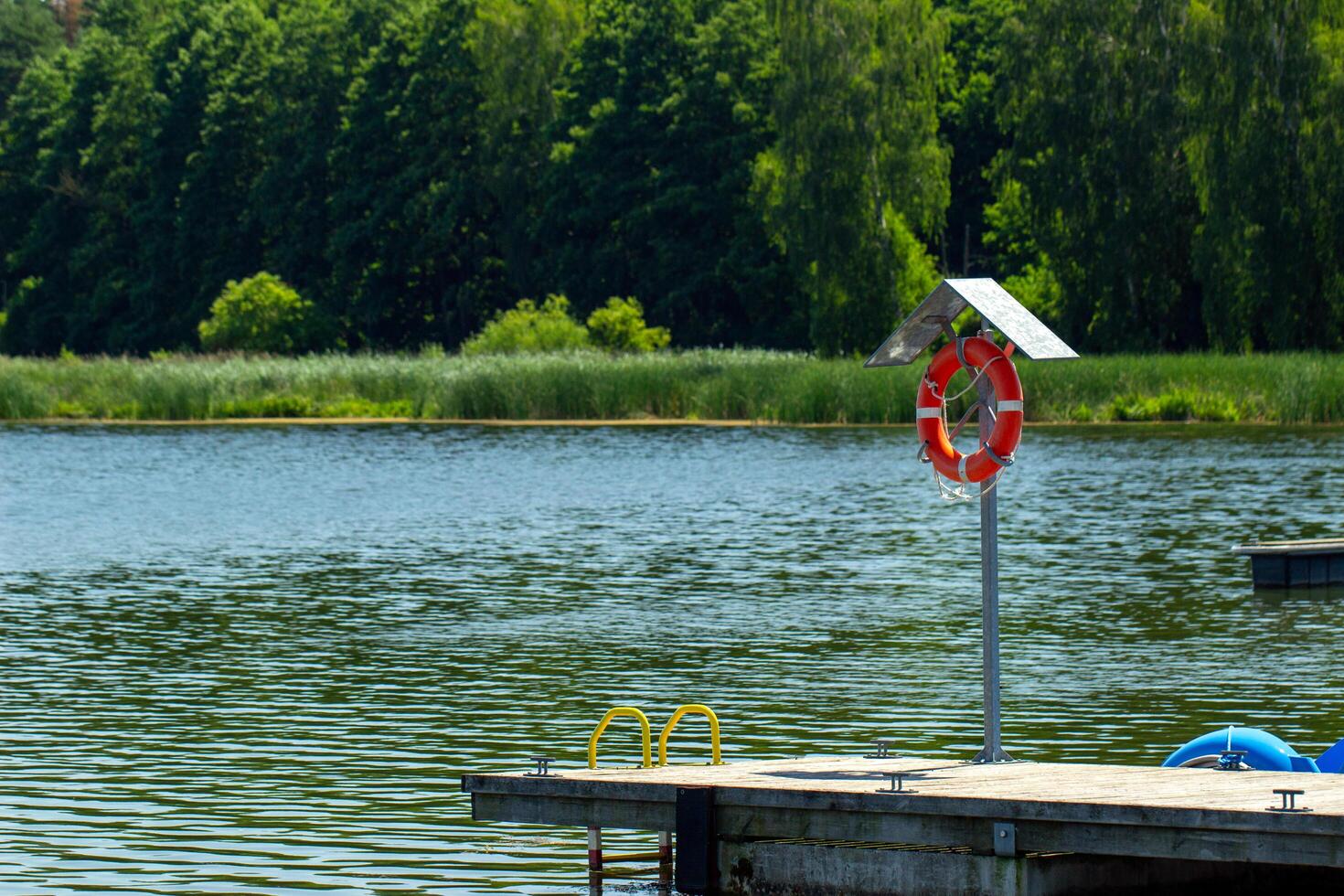 a dock with a life preserver and a red and white life preserver photo