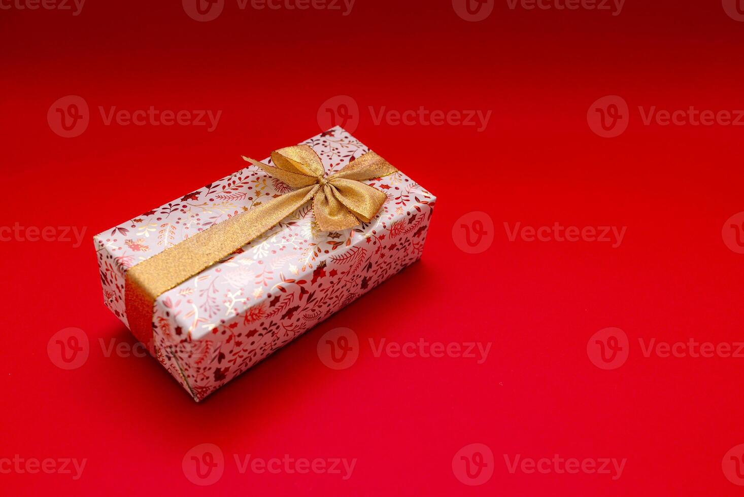 a gift box with a bow on a red background photo