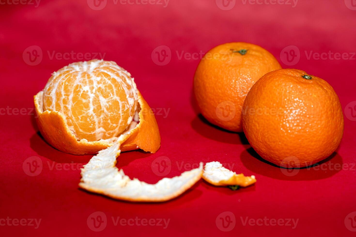a peeled orange on a red surface photo