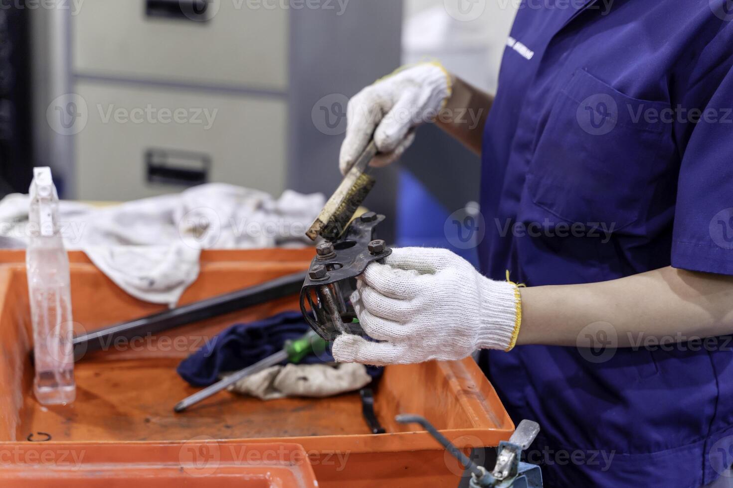 Closeup and crop Construction worker, Engineer wearing uniform working clean work piece in industrial workshop. photo