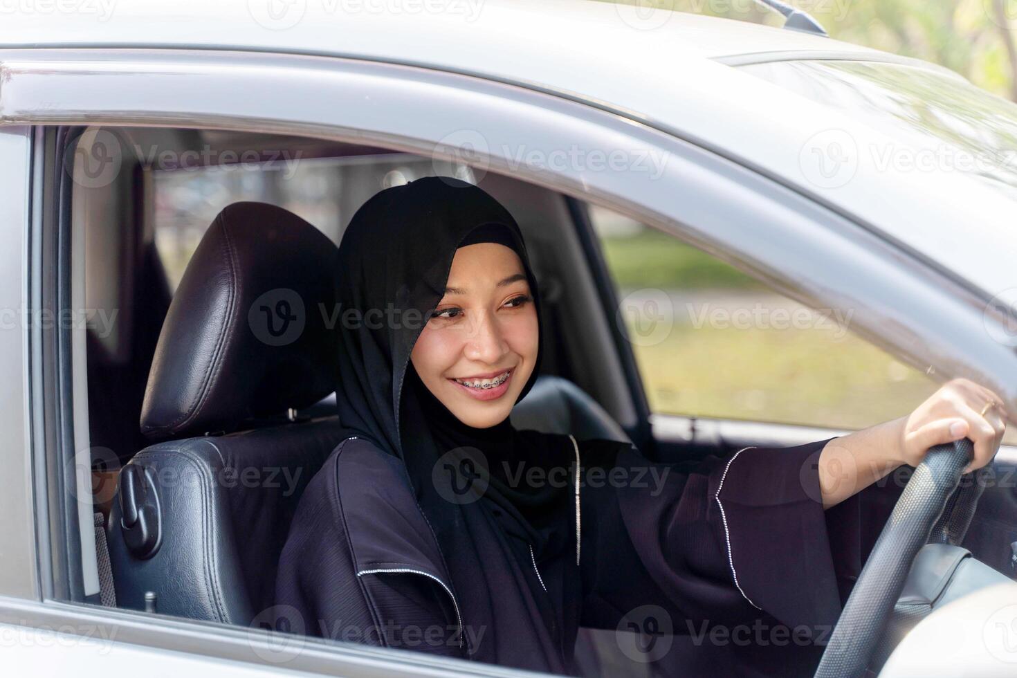 Closeup a beautiful Muslim woman in Abaya niqab traditional clothes driving a car in city photo