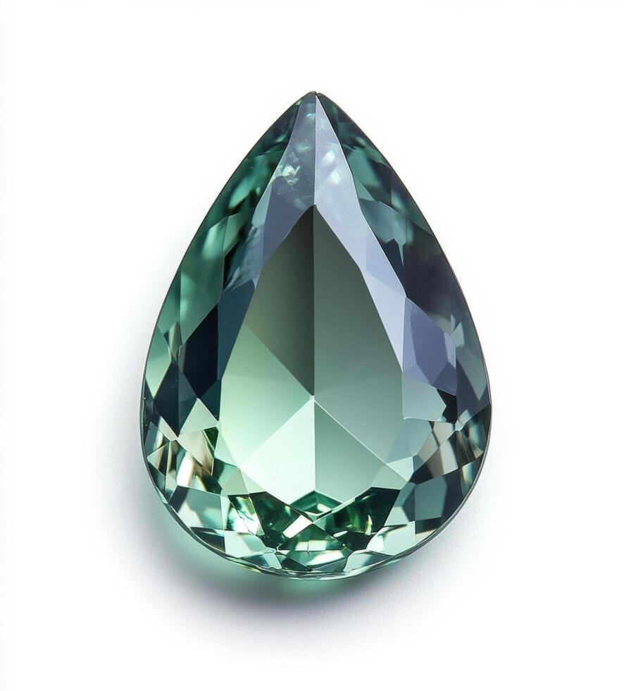 Sparkling teal gemstone in a tear drop shape illuminated by soft light showing intricate cuts and reflections on photo