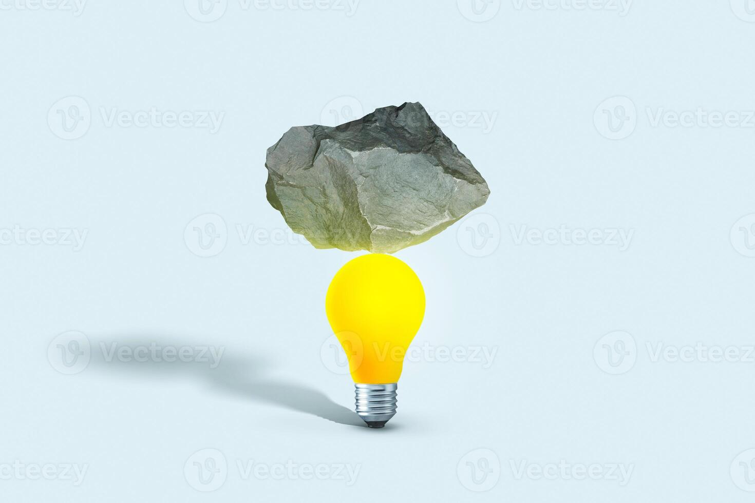 Stone put on yellow light bulb floating on blue background. minimal creative idea concept. Balance, creative idea. Startup, concept photo