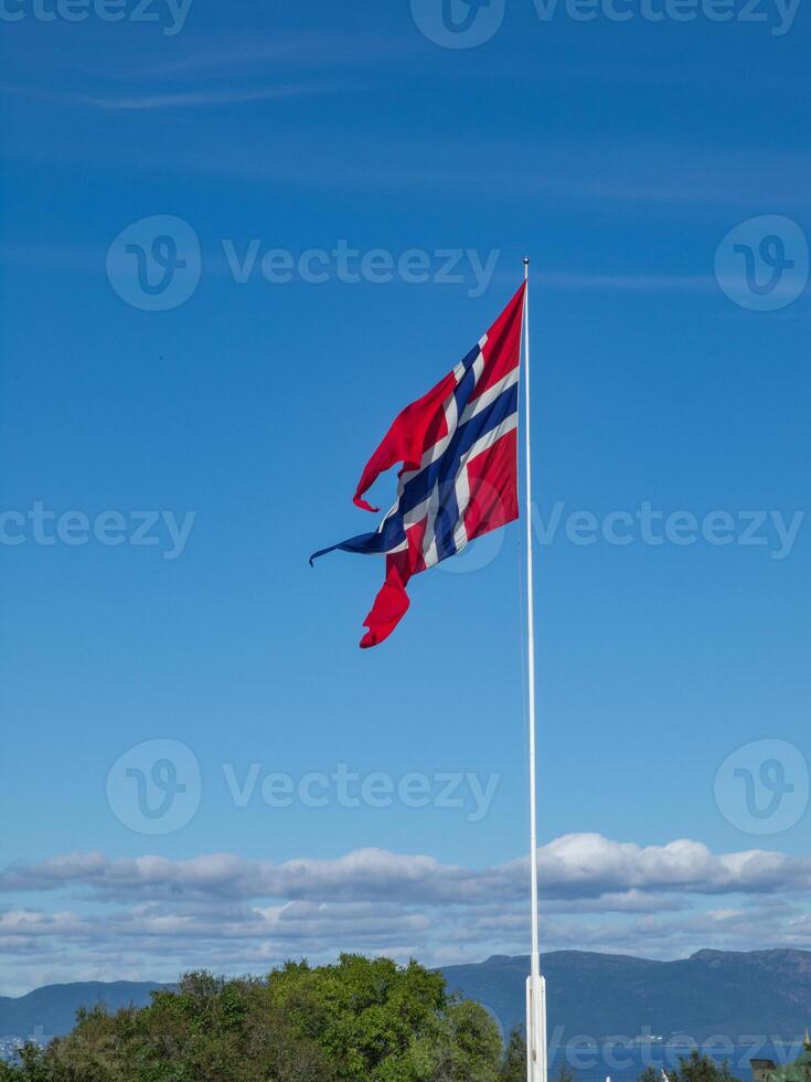 A blue sky with white clouds and a norwegian banner photo