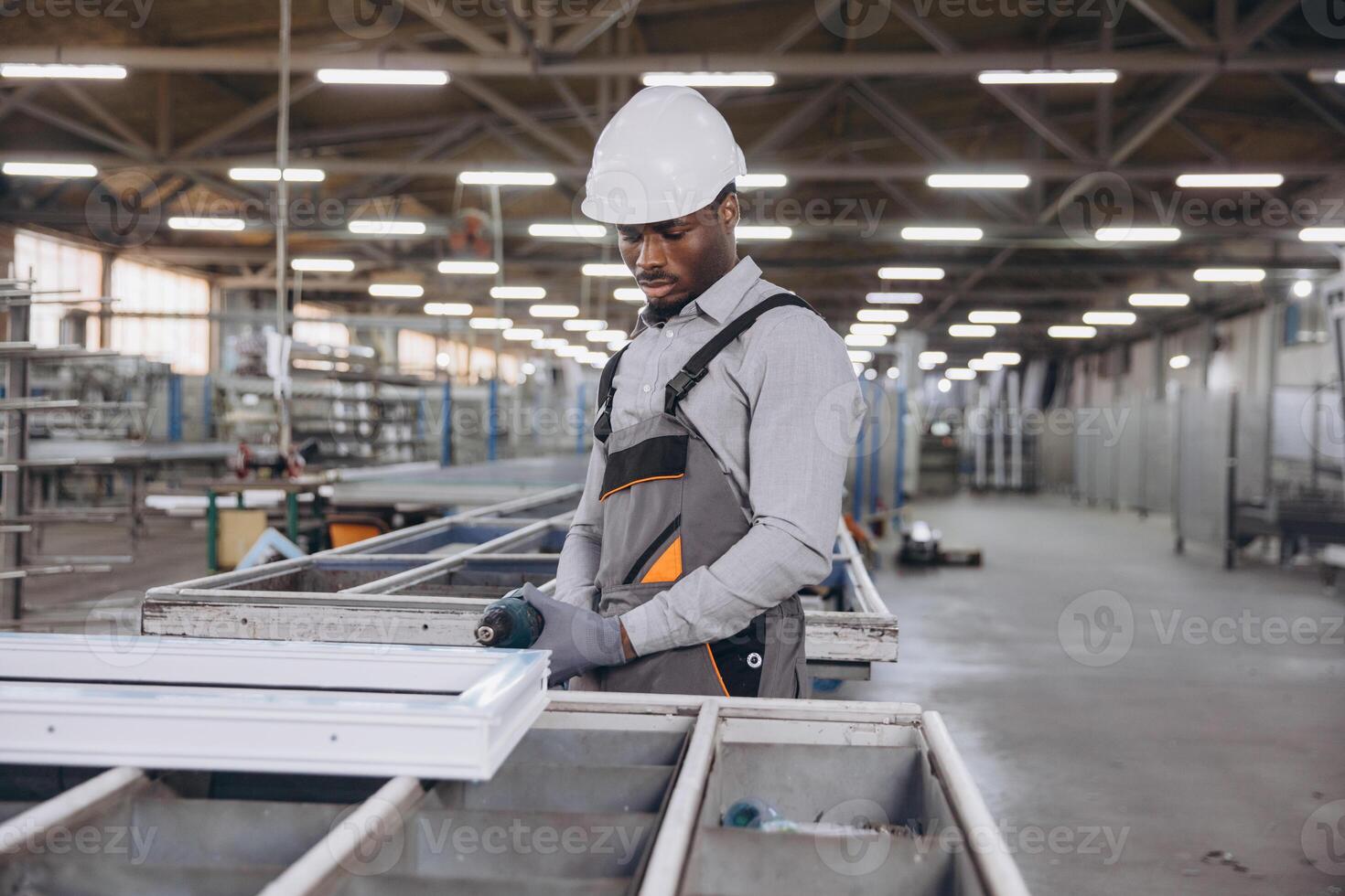 Factory worker assembling aluminum window frames on production line photo