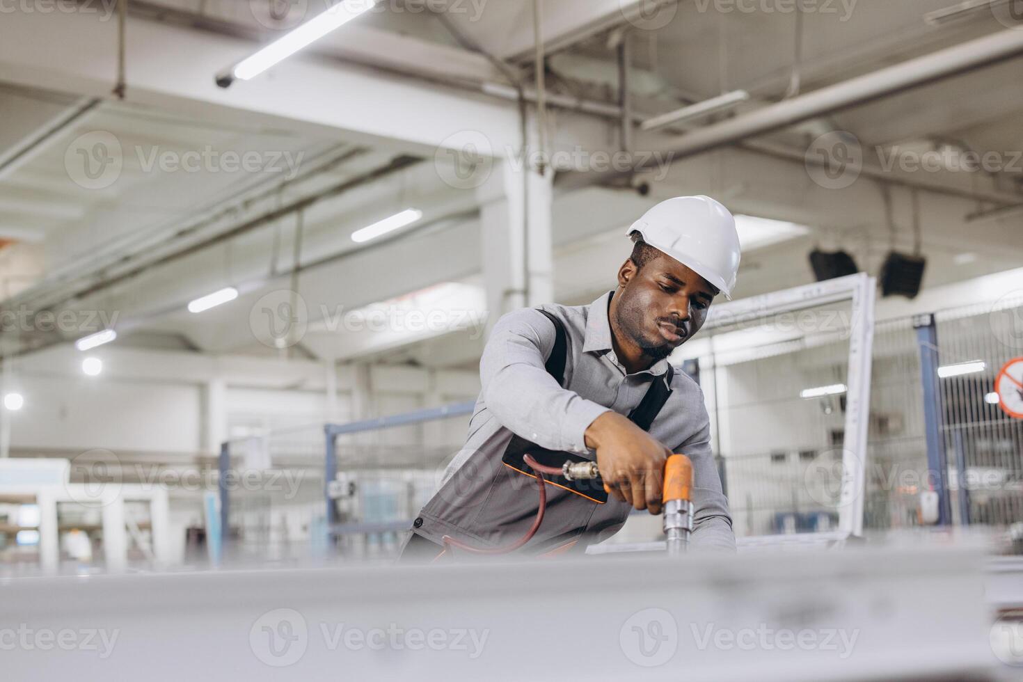 Factory worker assembling aluminum and pvc window frames in production line photo
