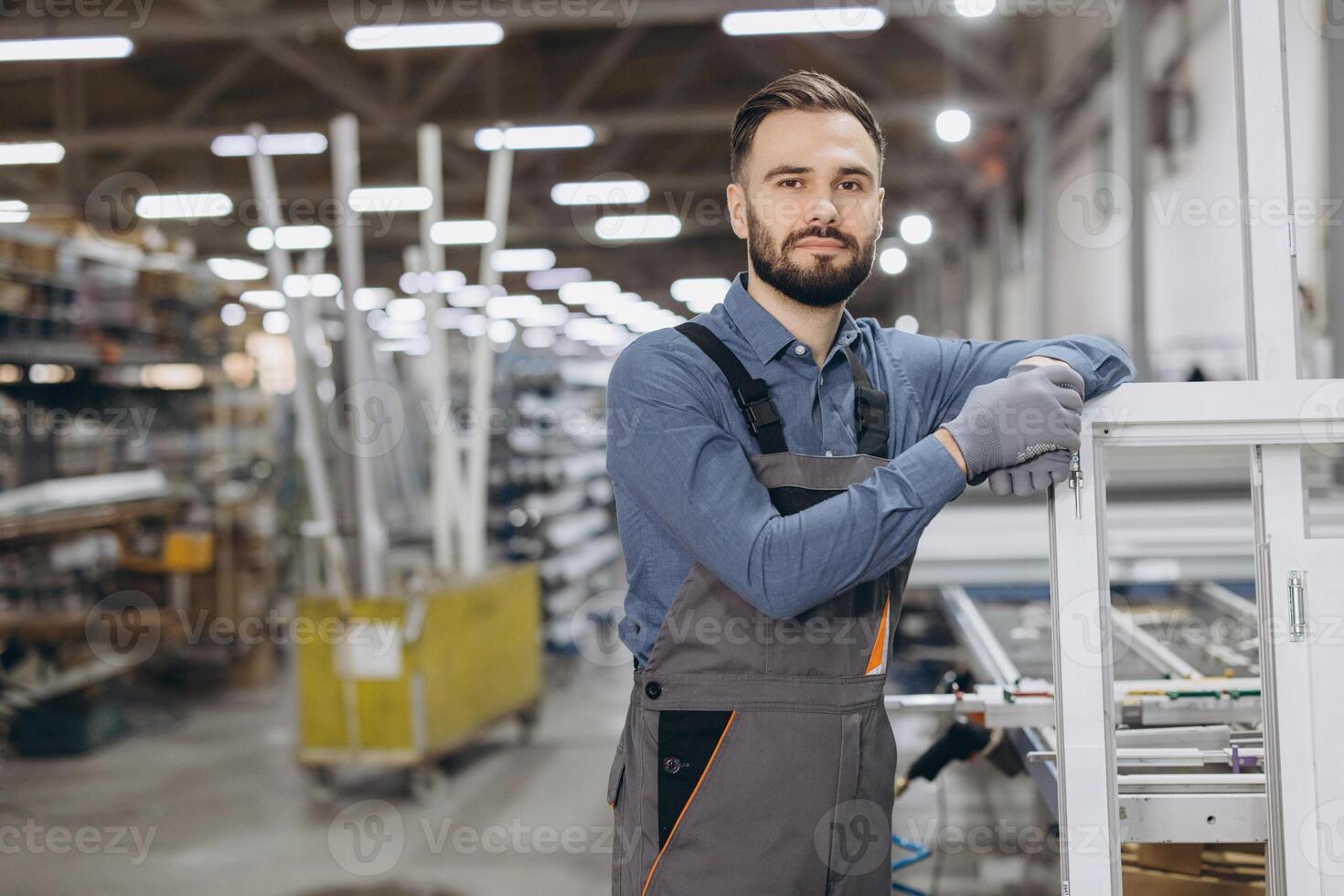 Factory worker leaning on PVC window frame in warehouse photo