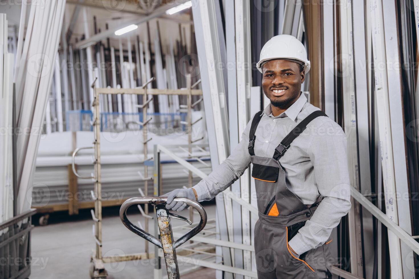 Factory worker transporting aluminum and pvc window and door frames photo