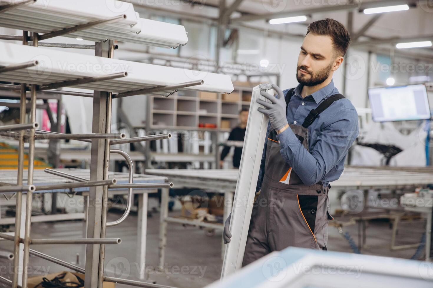 Factory worker holding pvc window profile in production line photo