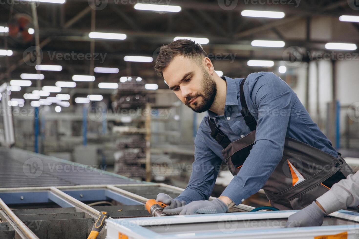 Factory worker assembling aluminum window frame on production line photo