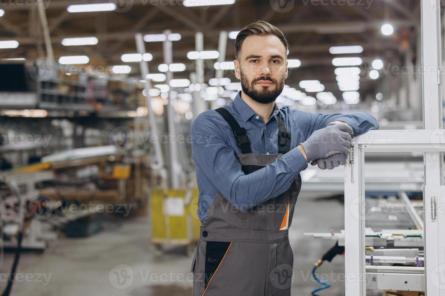 Factory worker posing leaning on a window frame photo