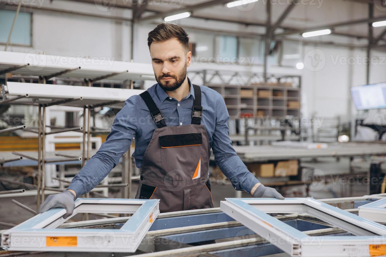 Factory worker assembling pvc windows in production line photo