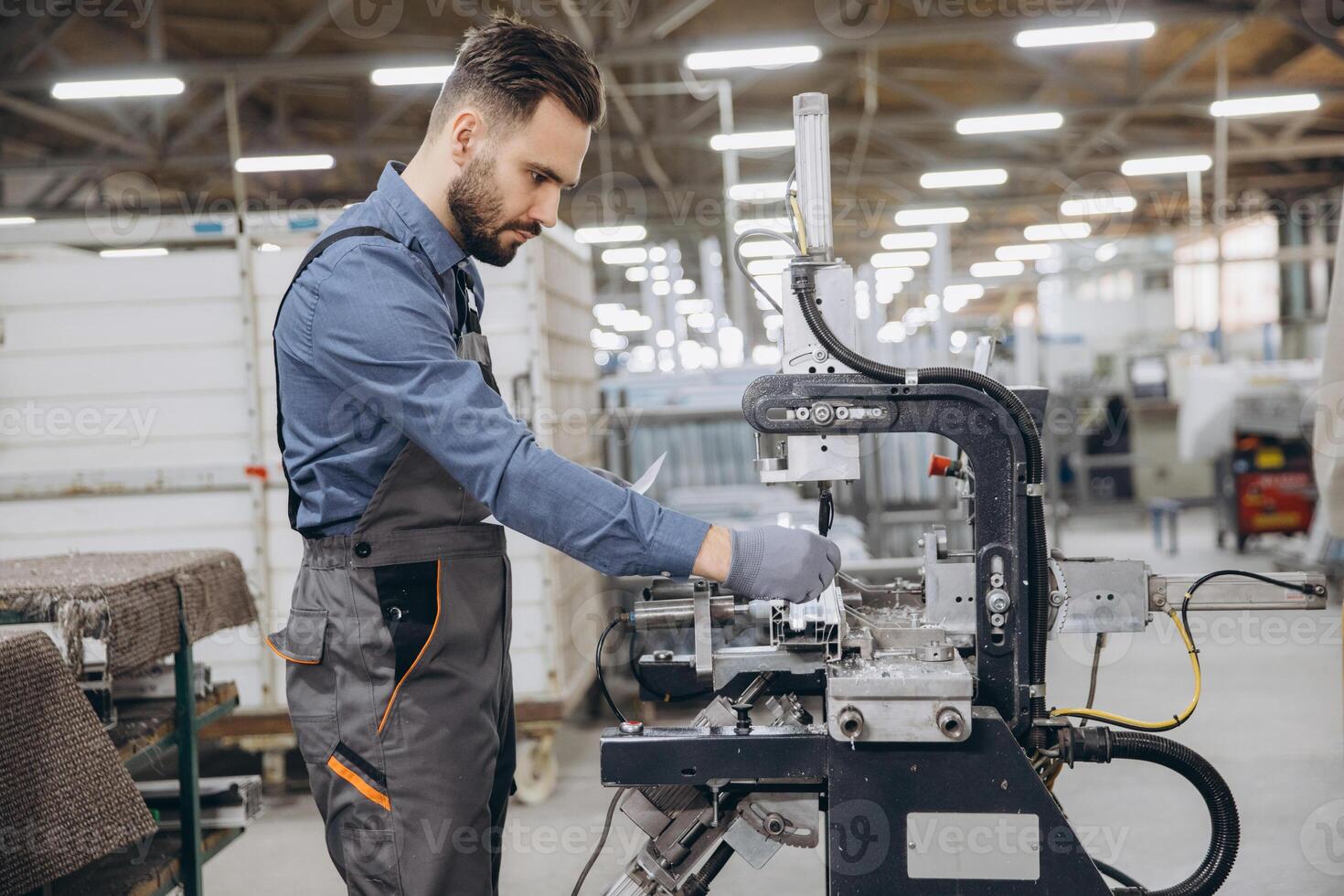 Factory worker operating machinery producing aluminum and pvc windows and doors photo