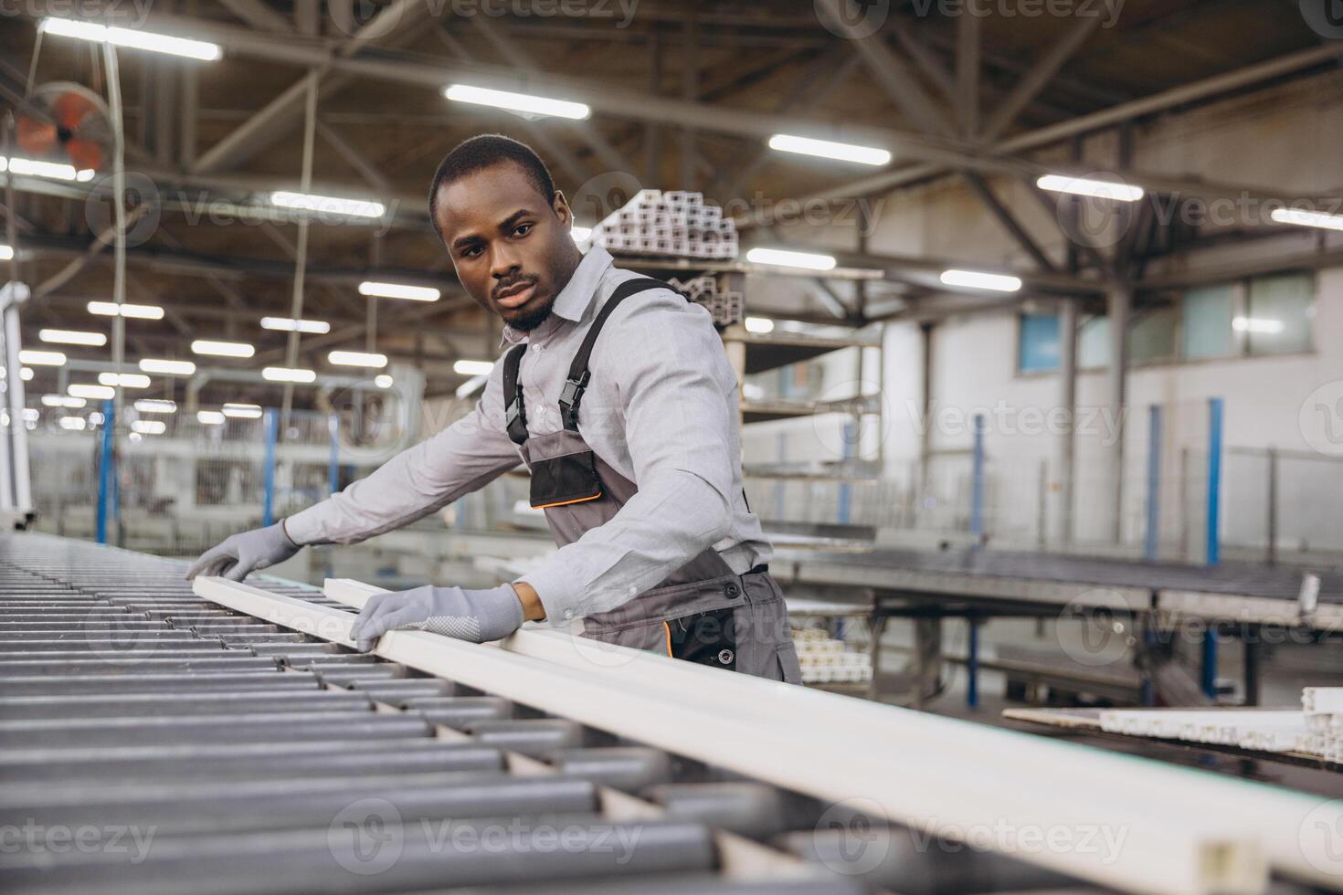 Factory worker handling pvc window frame on production line photo