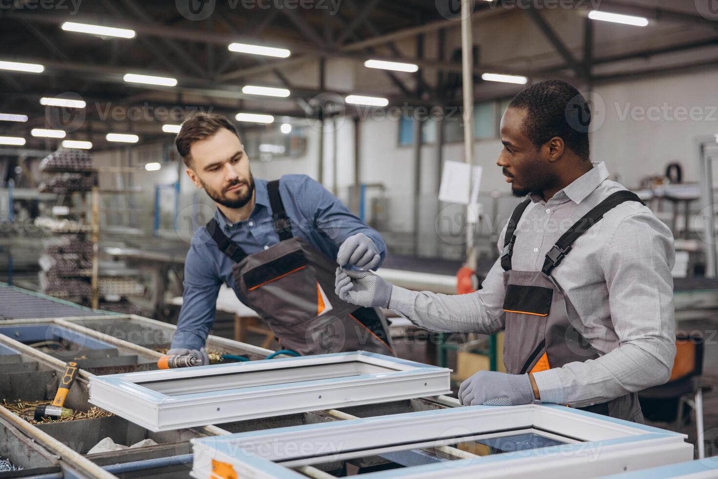 Factory workers assembling PVC windows in production line photo