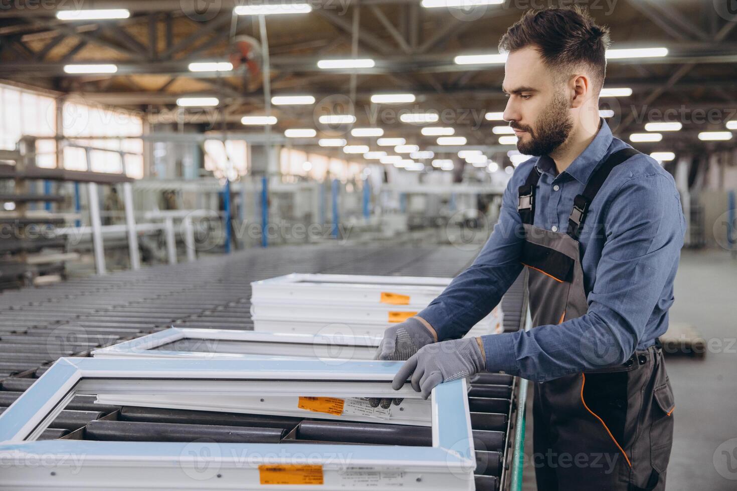 Factory worker checking PVC window frames on production line photo