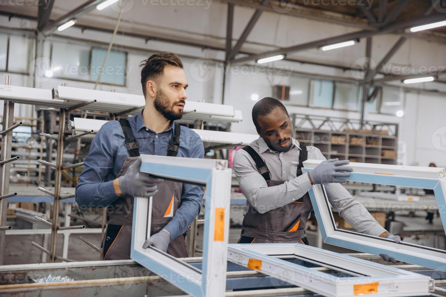 Factory workers assembling PVC windows in production line photo