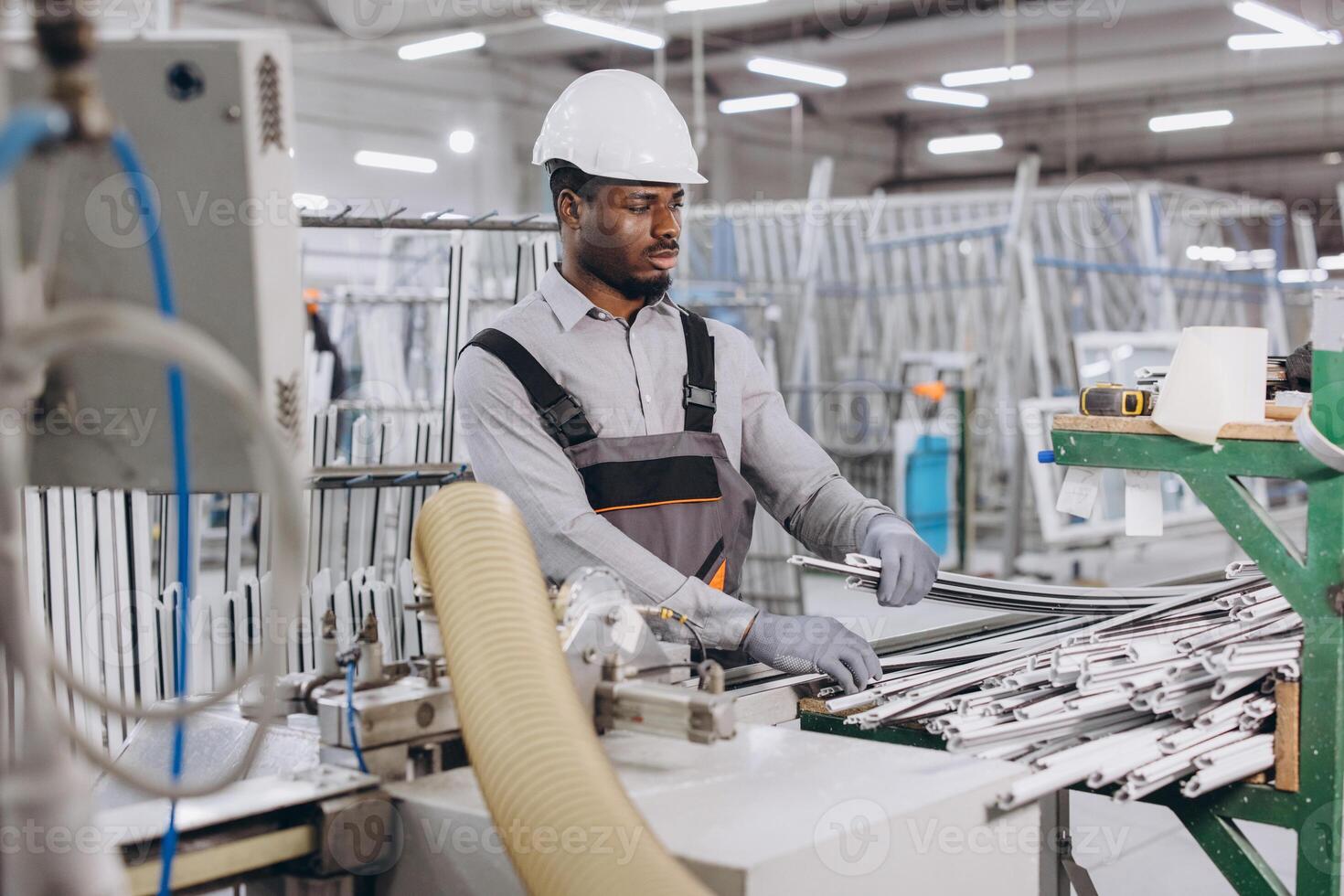 Factory worker handling aluminum profiles for windows and doors production photo
