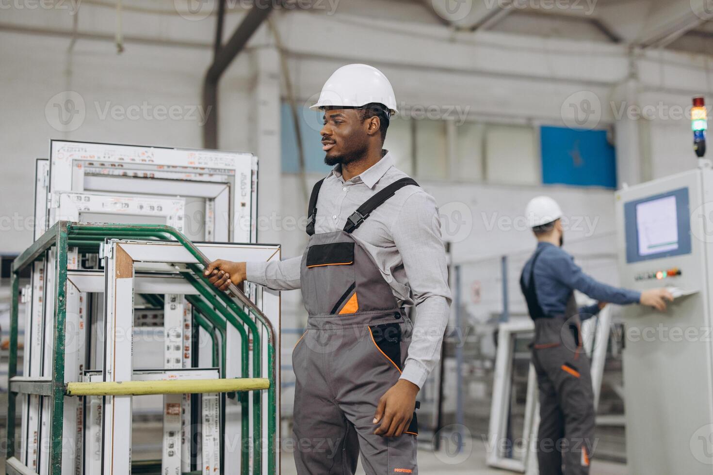 Factory worker moving aluminum window frames on production line photo