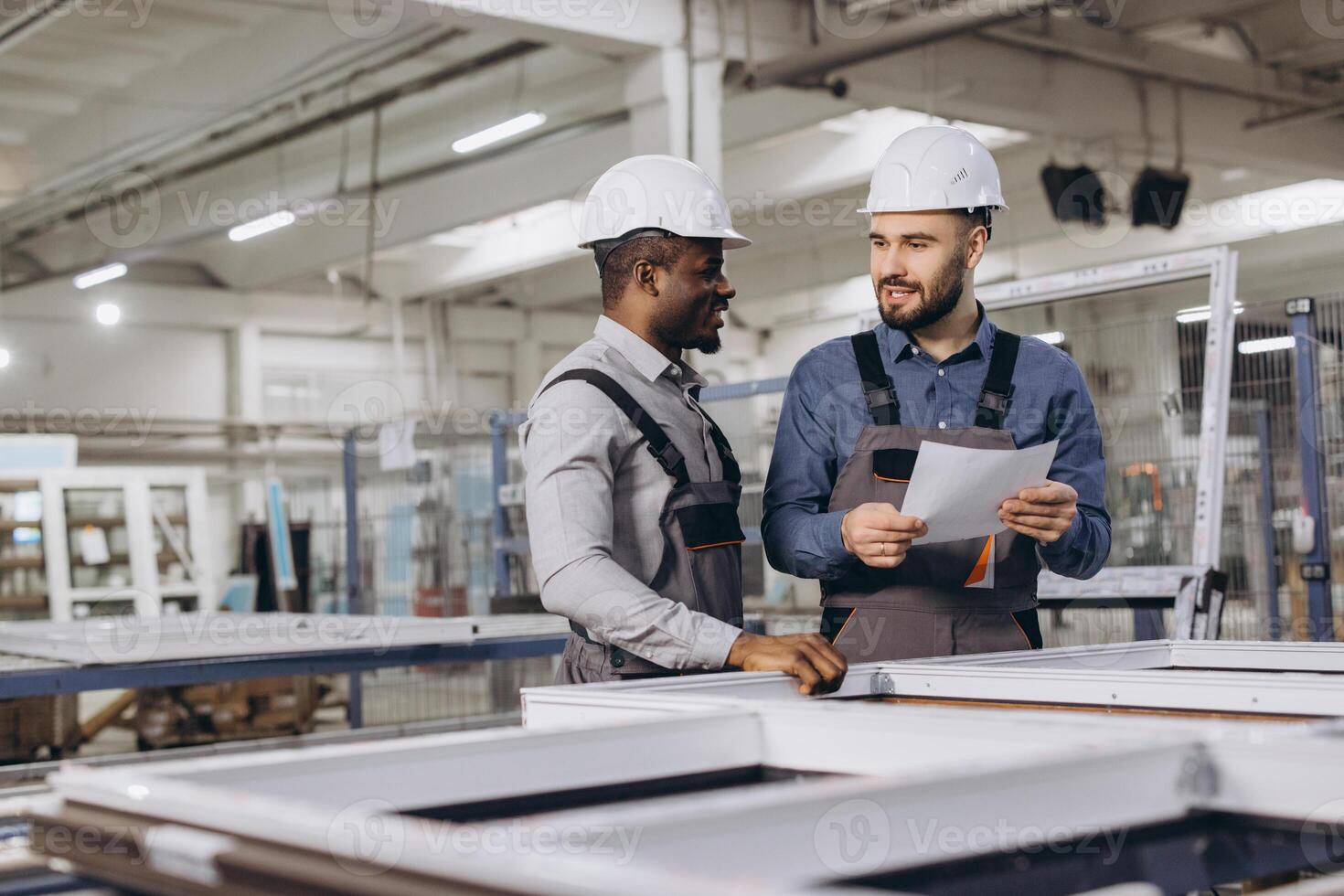 Factory workers discussing aluminum window frame production photo