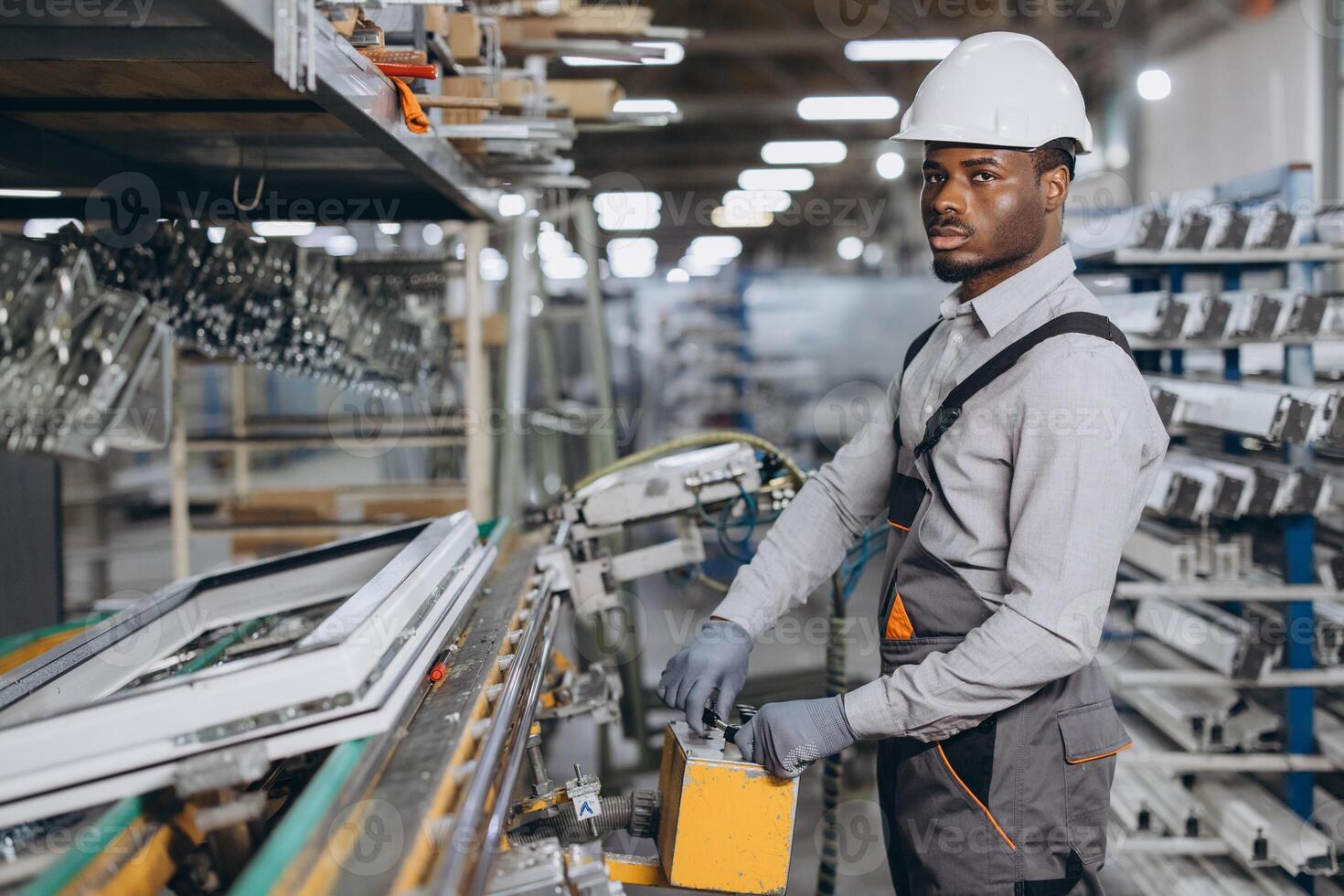 Factory worker operating machinery producing PVC windows and doors photo