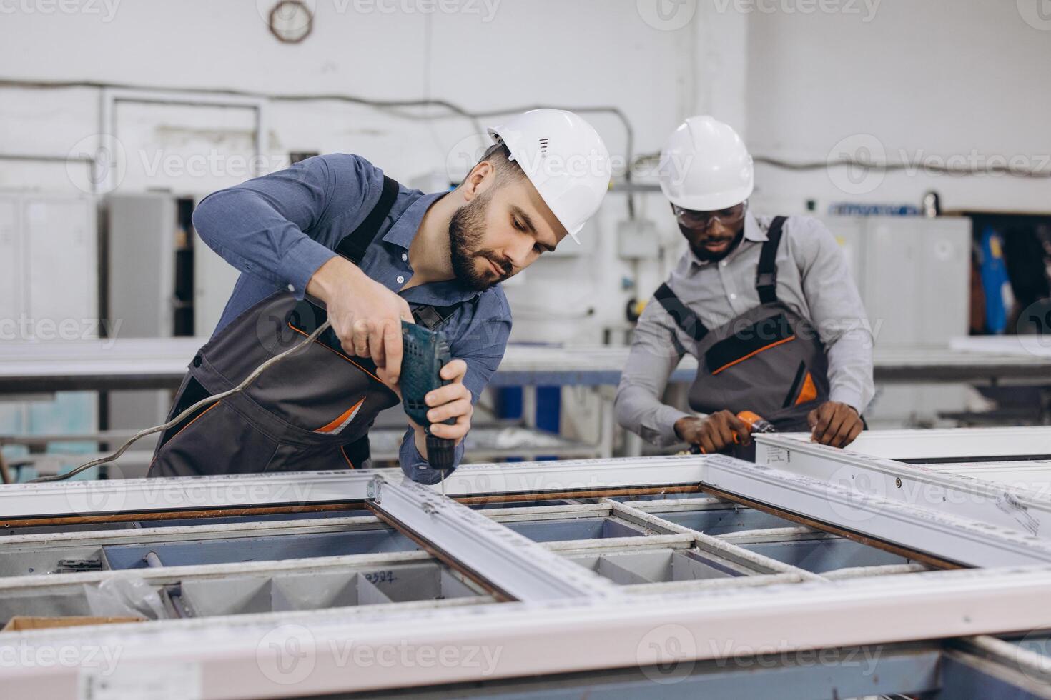 Factory workers assembling PVC window frames in production line photo