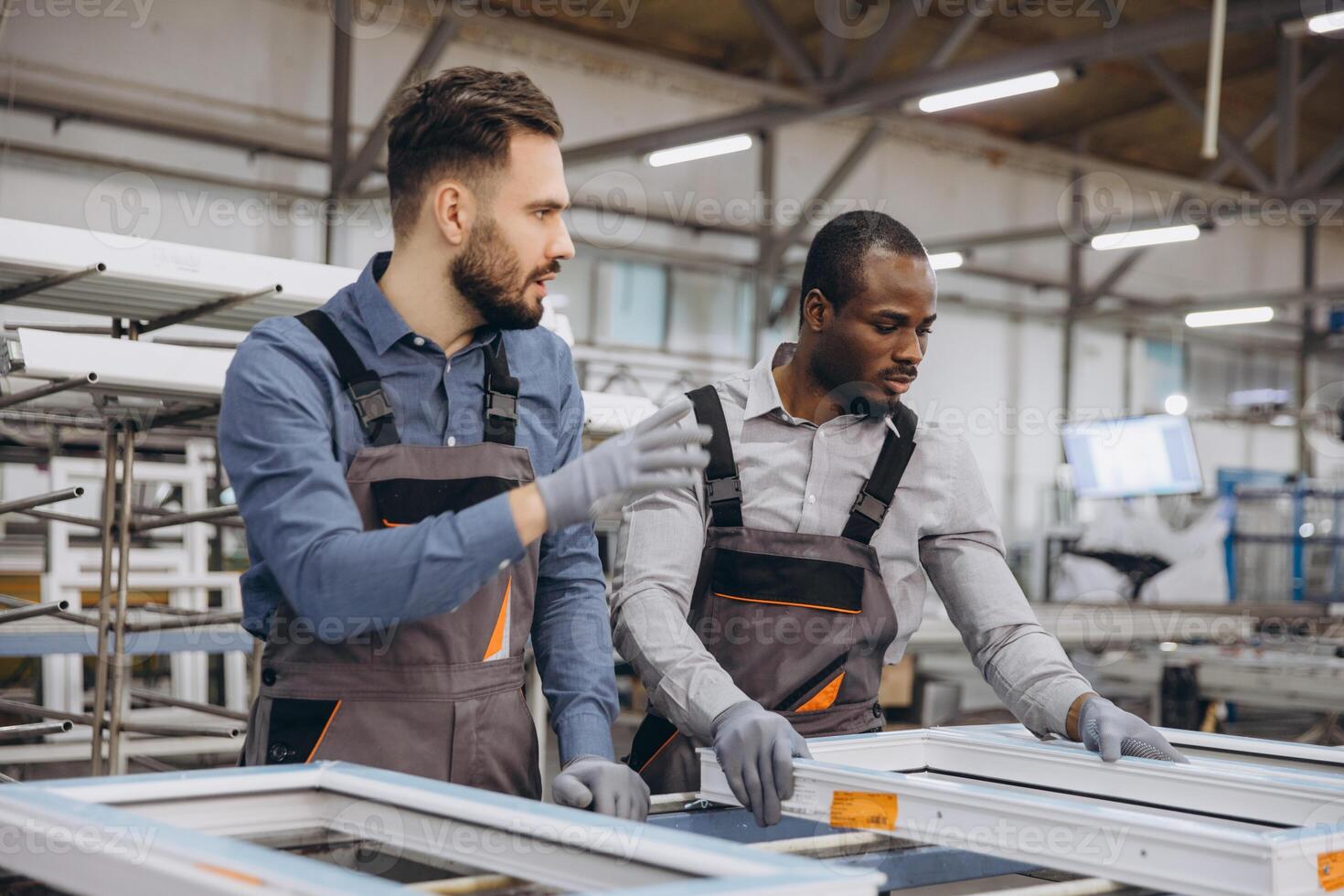 Factory workers assembling aluminum and pvc window frames in workshop photo