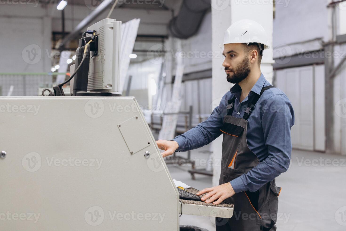 Factory worker operating industrial machinery for aluminum and PVC windows and doors production photo