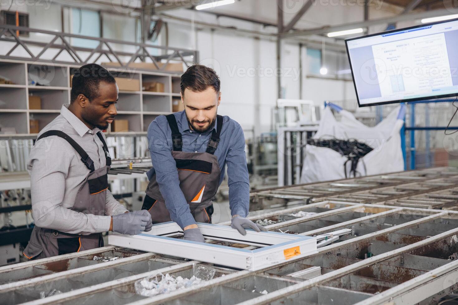 Factory workers assembling aluminum window frame in production line photo