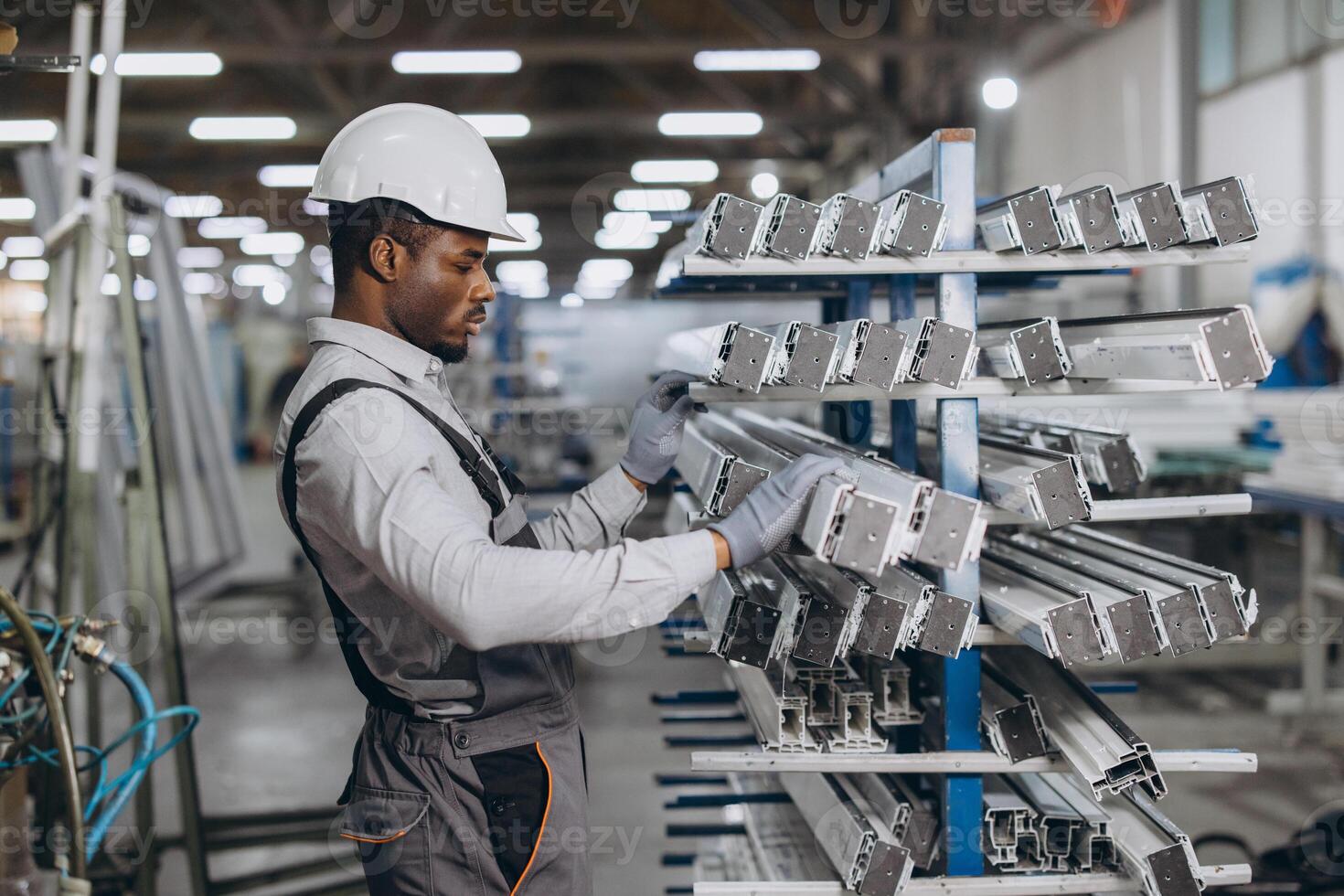 Factory worker checking aluminum profiles for windows and doors production photo