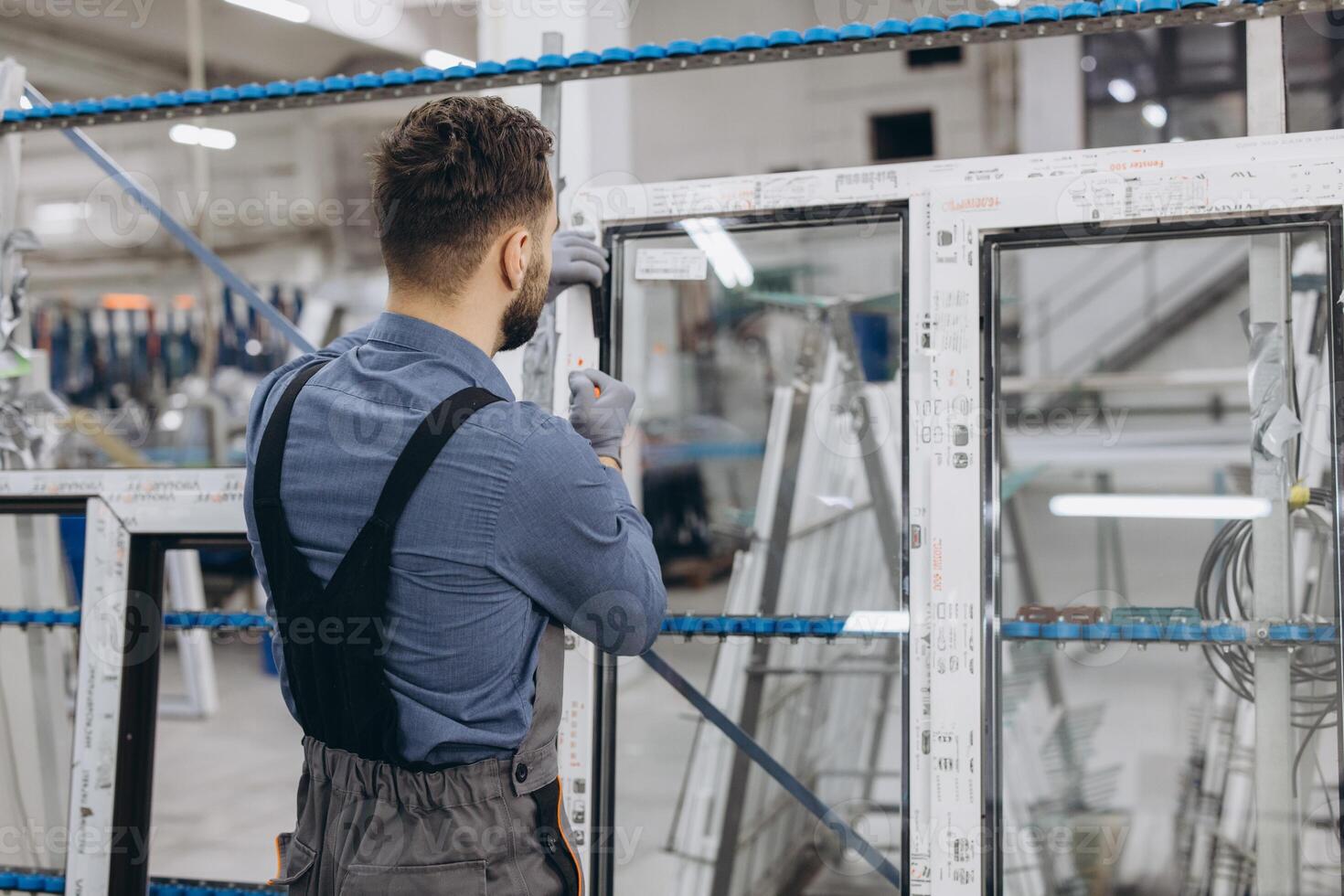 Factory worker assembling aluminum and pvc window frame in production line photo