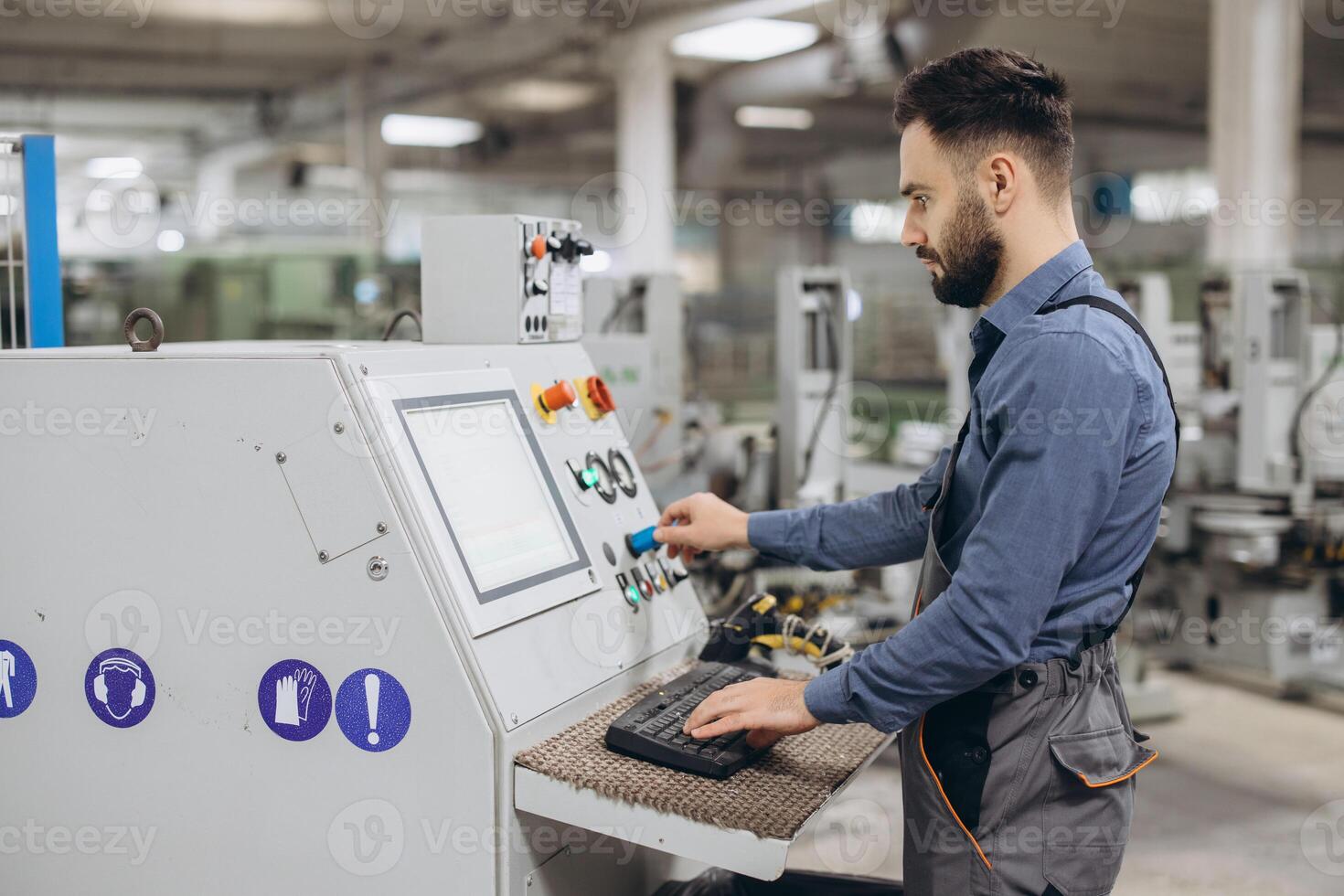 Factory worker operating industrial machinery producing PVC windows and doors photo