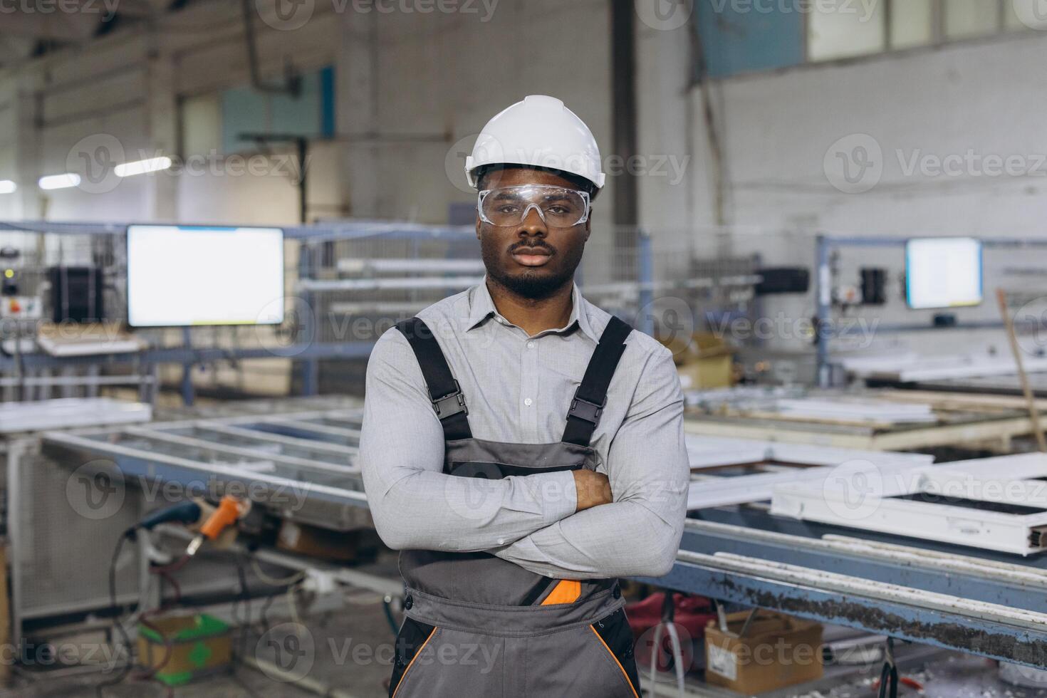 Technician posing with crossed arms in a window factory photo