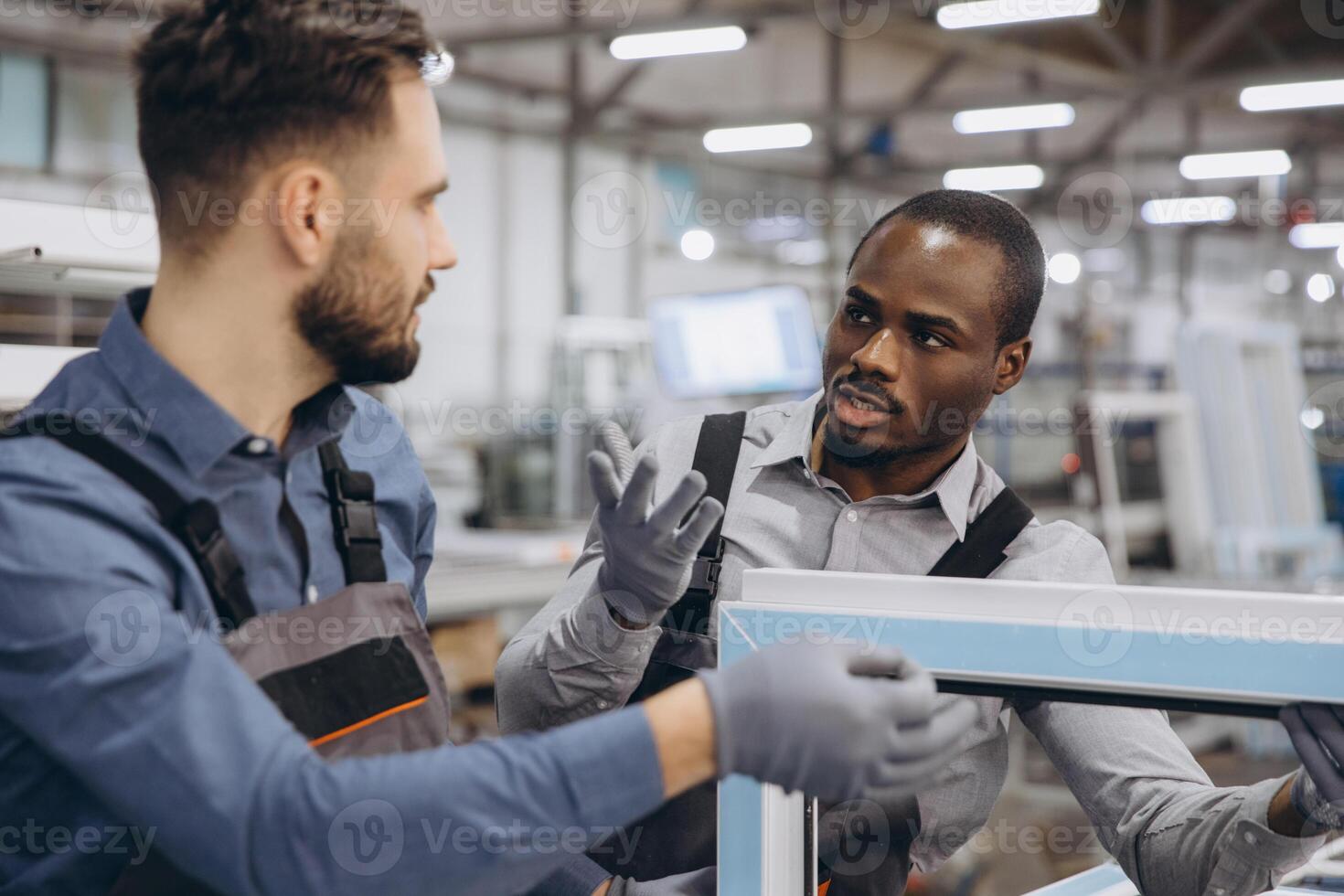 Factory workers discussing aluminum window frame production process photo
