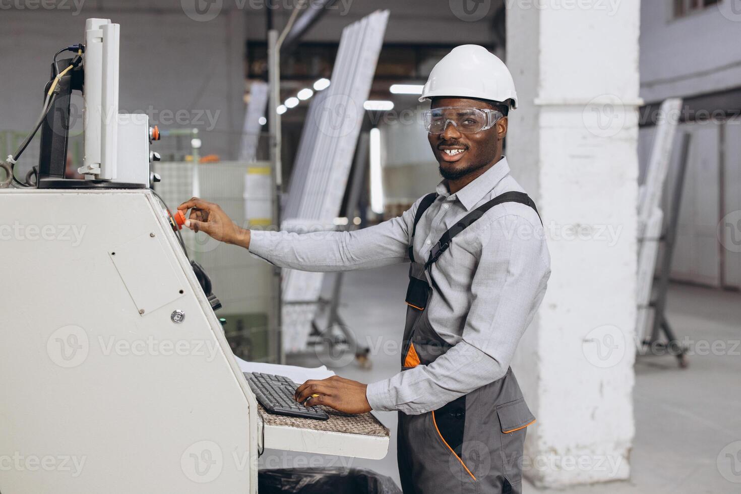 Factory worker operating machinery for aluminum and PVC windows and doors production photo