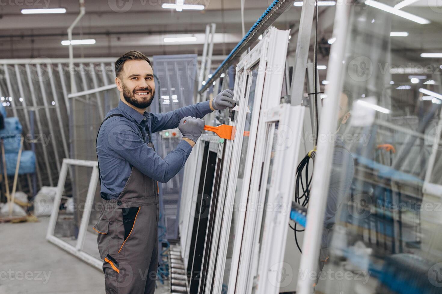 Factory worker assembling aluminum and PVC window frames in production line photo