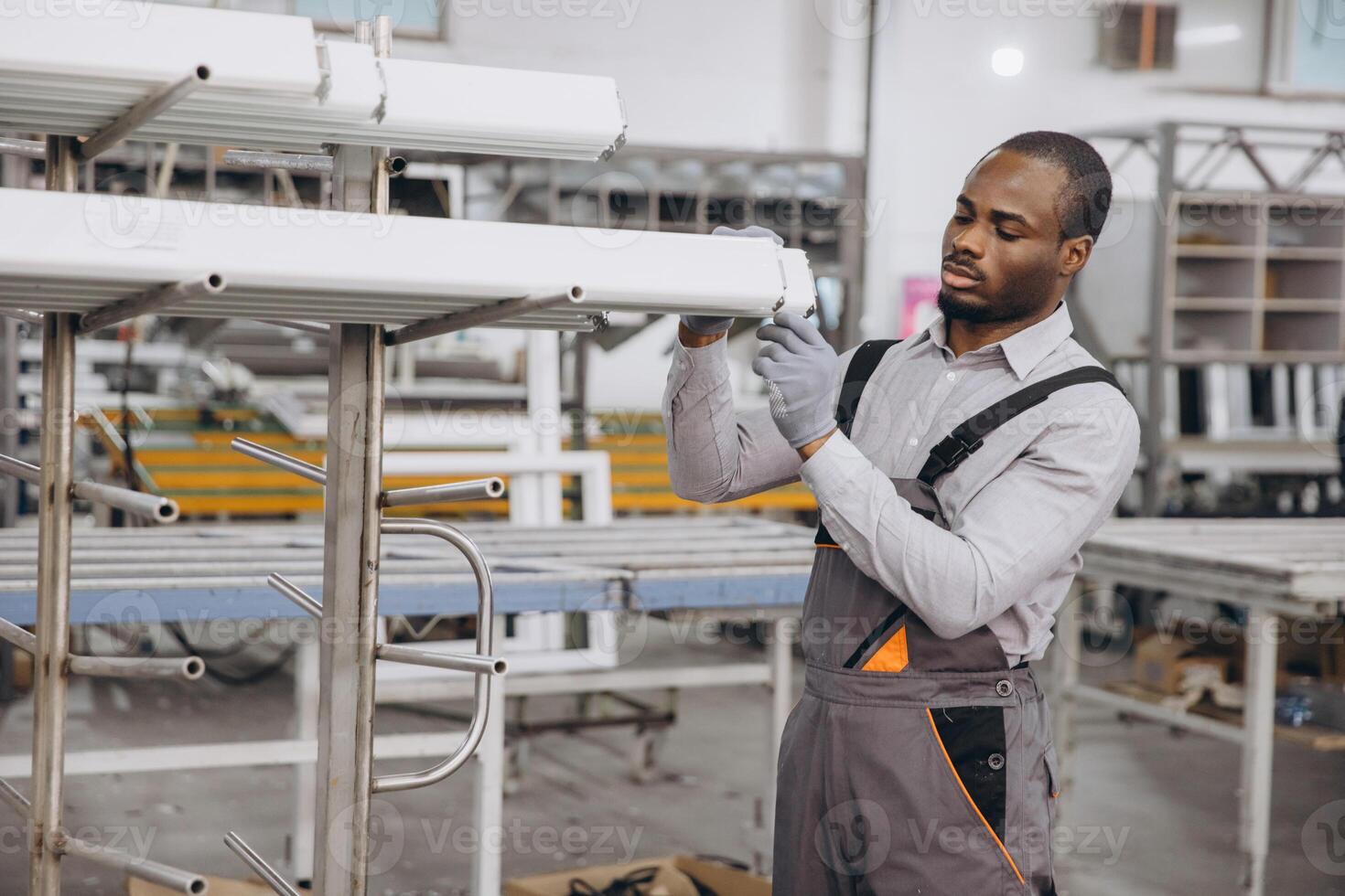 Factory worker inspecting aluminum profiles for windows and doors production photo