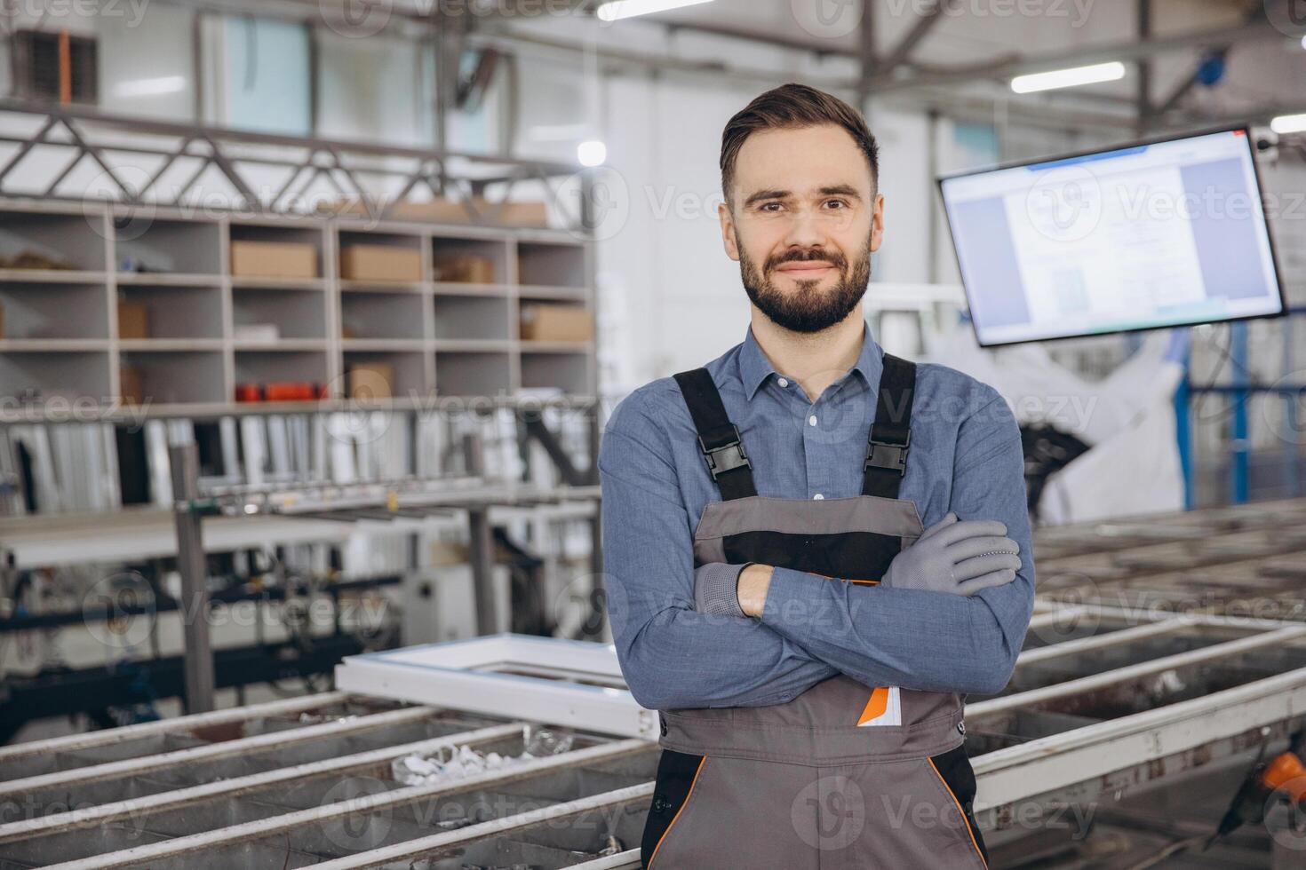 Factory worker posing with crossed arms in a PVC windows and doors production line photo