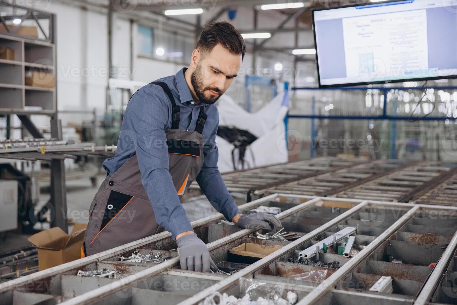 Factory worker preparing aluminum profiles for windows and doors production photo